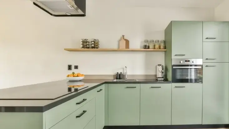 Soft green kitchen with flat slab cabinet doors and drawer fronts